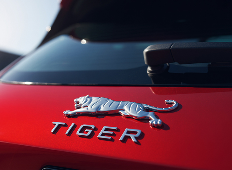 chrome emblem for cars showing TIGER badge on red trunk lid